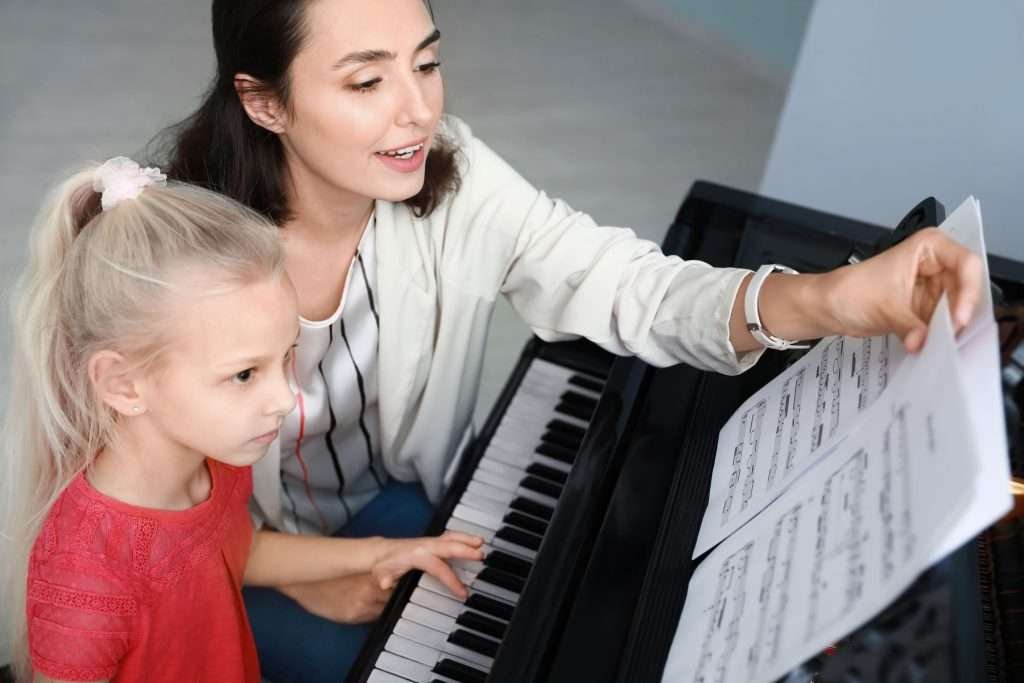 A music instructor guiding her beginner student in their private piano lessons