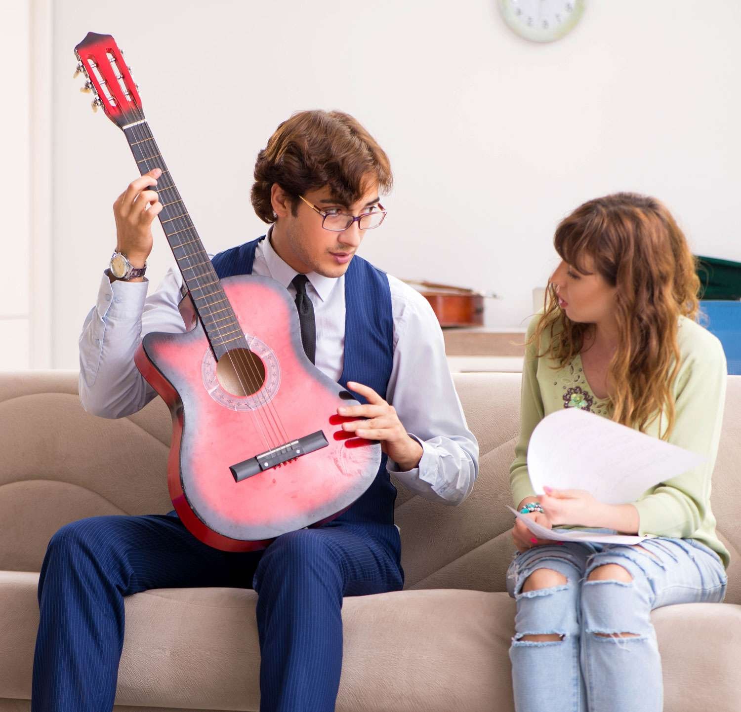 guitar instructor explaining to his female student