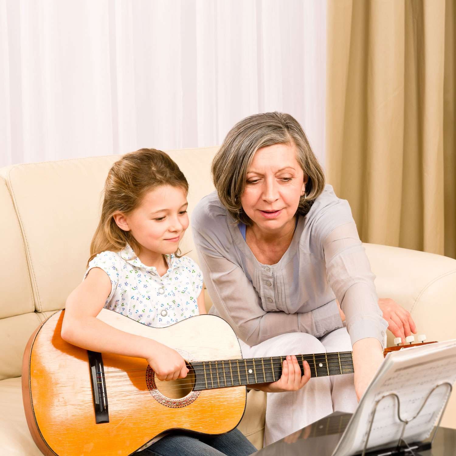 guitar instructor teaching her young female student
