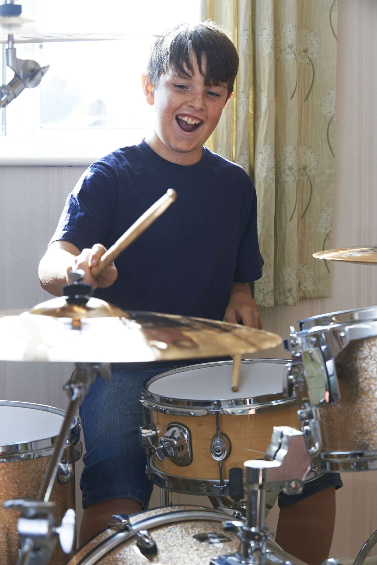 Happy boy playing the drums