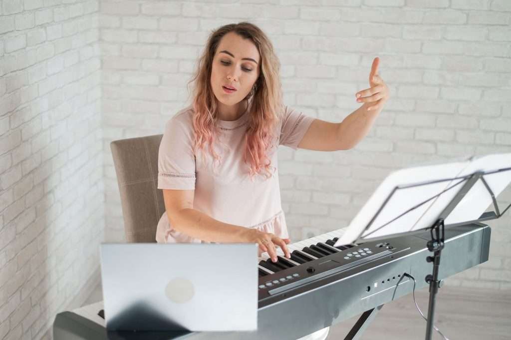 music instructor giving piano lesson online