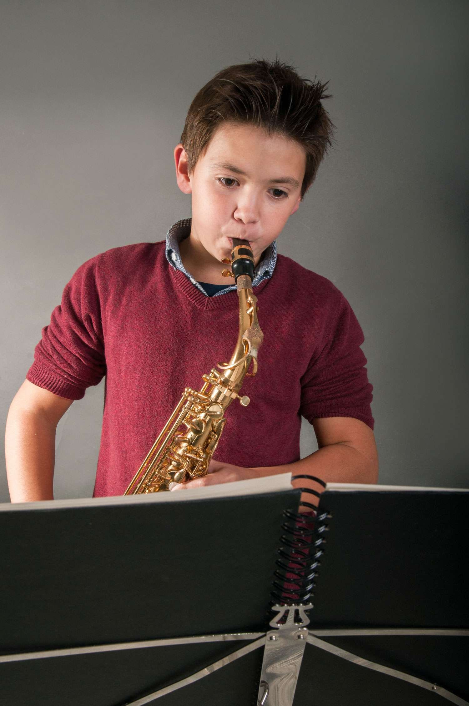 young boy student playing saxophone