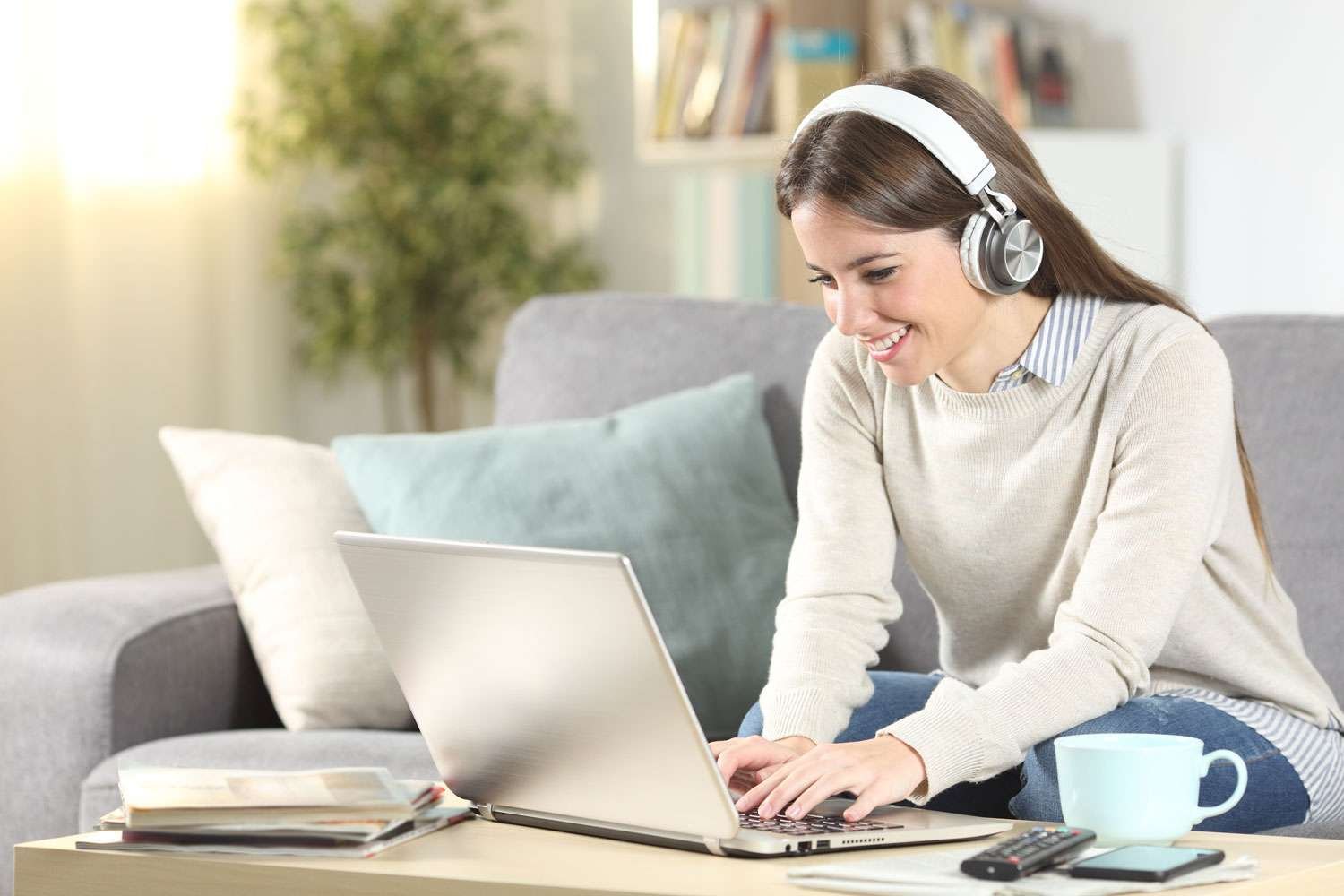 young female in front of laptop wearing headphones