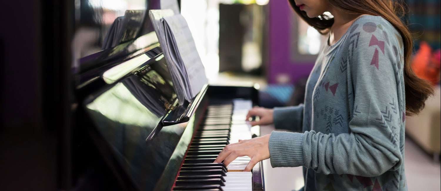 young female playing the piano keys