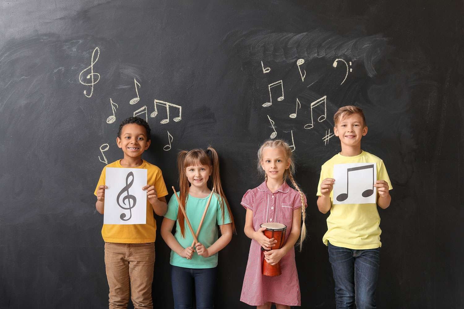 young music students standing against grey chalkboard