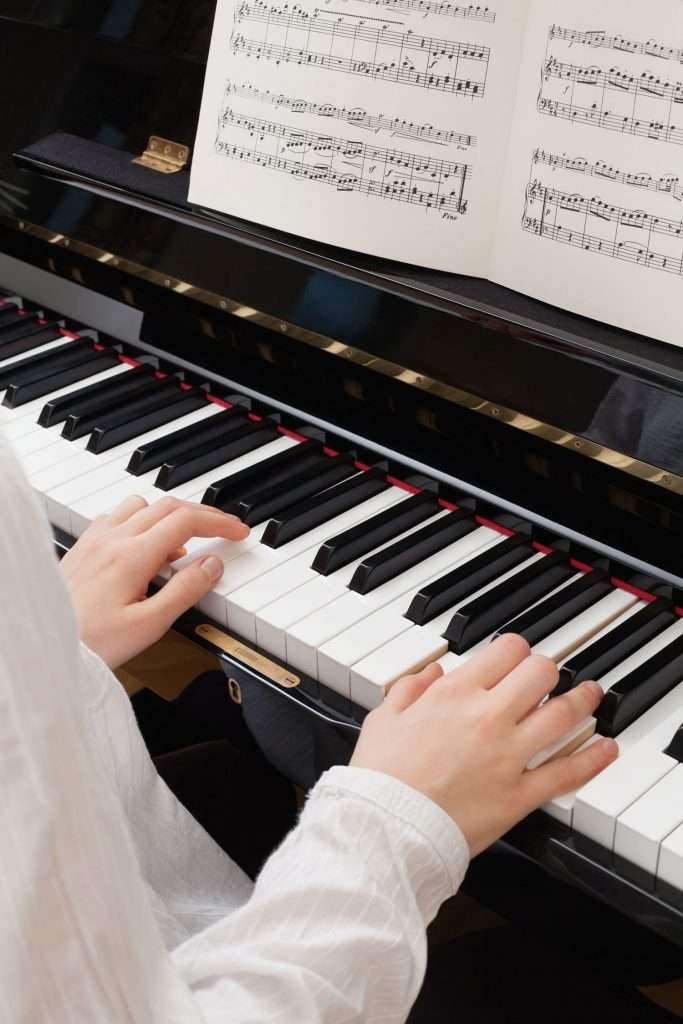 a pianist's hands playing the piano, sheet music